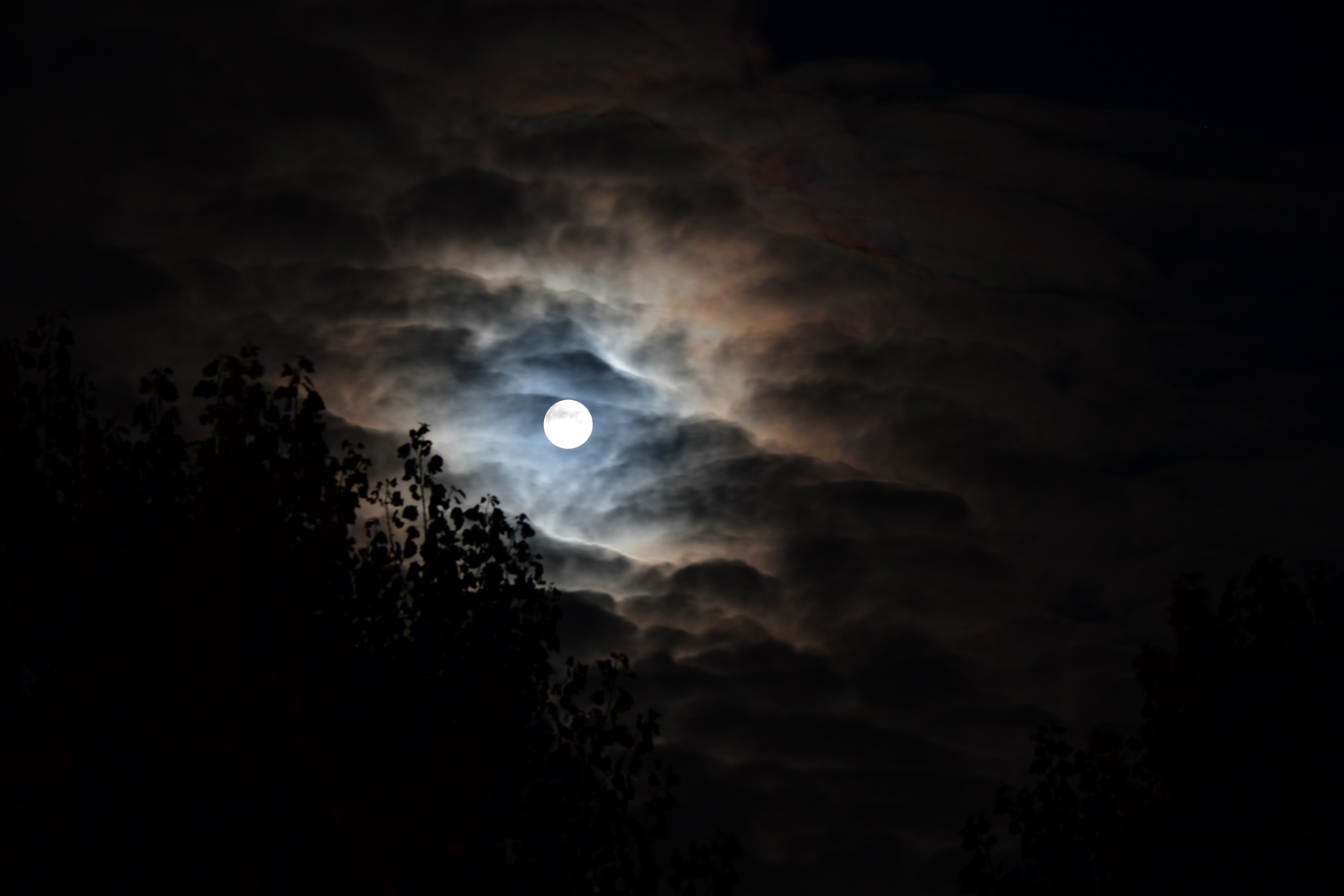 Full moon nested in dark clouds
